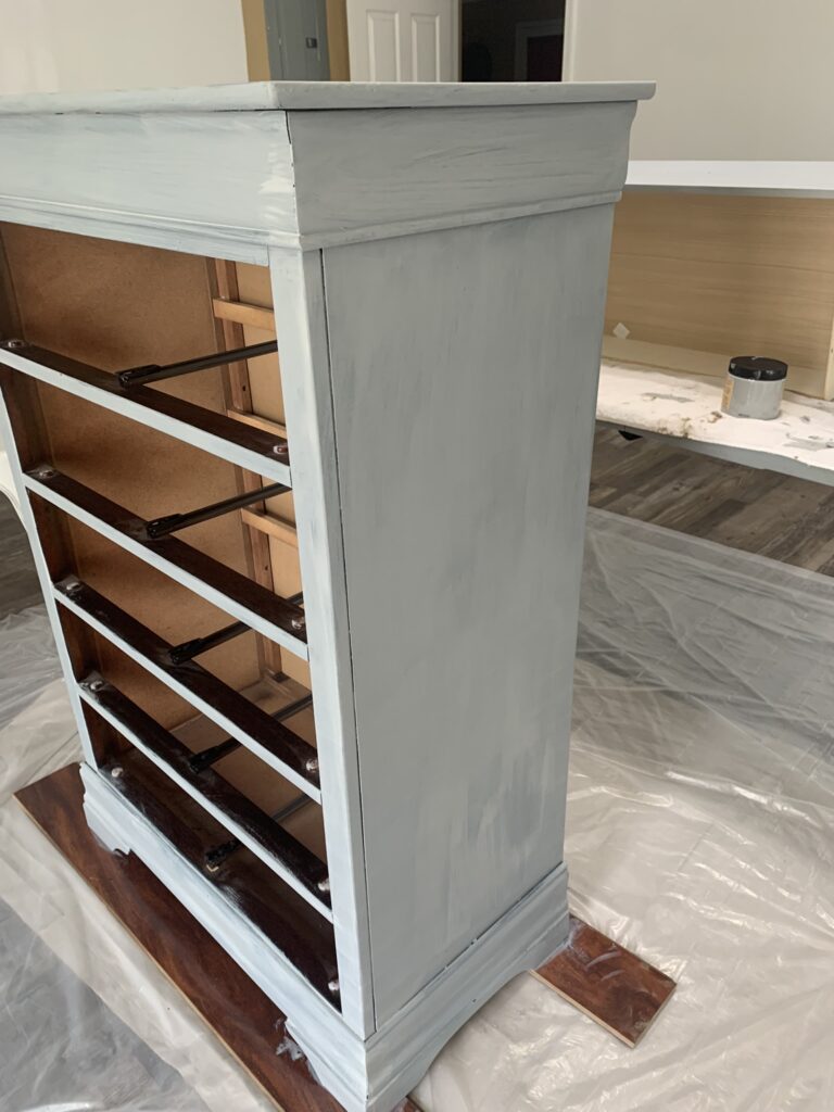 The chest of drawers with one coat of paint.
